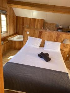 un lit dans une chambre avec une baignoire et un lit sidx sidx sidx sidx dans l'établissement BEAU CHALET DE MONTAGNE SERRE CHEVALIER AU PIED DES PISTES PLEIN SUD, à La Salle Les Alpes