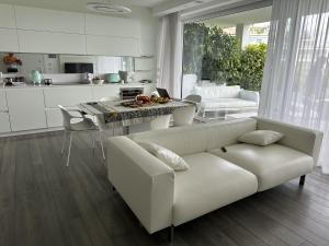 a living room with a white couch and a table at Garda Lake Luxury Life in Padenghe sul Garda