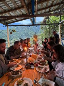 a group of people sitting at a table eating food at Guest House Mokvare in Gundauri