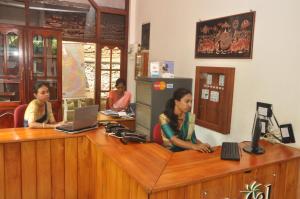 a group of women sitting at a desk with a laptop at Hotel Silan Mo in Mirissa