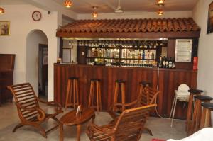 un bar con 4 sillas y una barra con alcohol en Hotel Silan Mo, en Mirissa