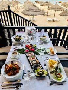 a table with plates of food on a table at a beach at Marhaba Royal Salem - Family Only in Sousse