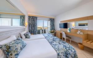 a hotel room with a large bed and a desk at Marhaba Royal Salem - Family Only in Sousse