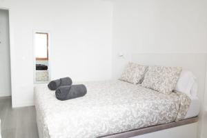 a white bedroom with a bed with two pillows at Los Cristianos Aqua Viva in Los Cristianos +9 photos