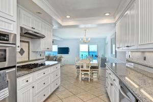 a kitchen with white cabinets and a dining room at Oceanfront Getaway, Private Beach, Fire Pit, 5BR in Oceanside