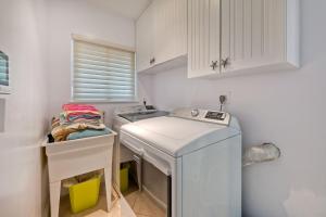 a small kitchen with a sink and a washing machine at Oceanfront Getaway, Private Beach, Fire Pit, 5BR in Oceanside +33 photos