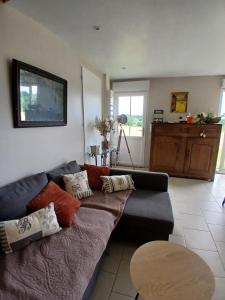 a living room with a couch and a table at la clé du bouton d'or in Leschelles