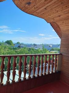 a balcony with a wooden railing with a view at Meerim Guest House in Bokonbayevo