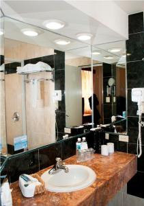 baño con lavabo y espejo grande en Hotel Marcella Clase Ejecutiva en Morelia