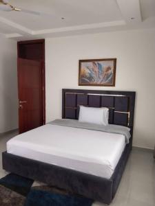 une chambre avec un grand lit avec une tête de lit en bois dans l'établissement Luxurious 1 Bedroom Apartment, à Ogbojo