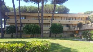 an apartment building with trees in front of it at Allure appartamento con piscina e posto auto in Cinquale