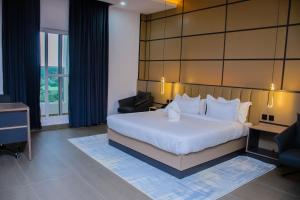 ein Hotelzimmer mit einem großen Bett und einem Schreibtisch in der Unterkunft G-Pinnacle Signature in Ilorin