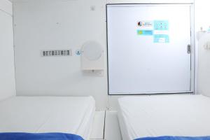 Postel nebo postele na pokoji v ubytování TAMU CAPSULE HOTEL