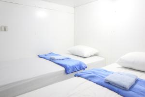 Postel nebo postele na pokoji v ubytování TAMU CAPSULE HOTEL