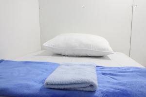 Postel nebo postele na pokoji v ubytování TAMU CAPSULE HOTEL
