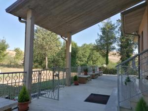 a covered porch with benches and potted plants at maria antonietta in Urbino