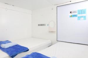 Postel nebo postele na pokoji v ubytování TAMU CAPSULE HOTEL