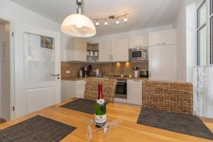 a kitchen with a table with a bottle of wine on it at Strandvilla Luv Lee Miramar in Rerik +28 photos