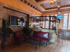a bar in a restaurant with two red chairs at Hôtel Ayachi in Tunis