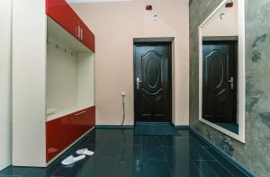 een hal met twee zwarte deuren en een spiegel bij Apartment Penthouse in Kiev