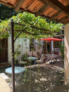 a patio with a table and chairs under a pergola at Bed & Breakfast Le Beauséjour in Carcassonne