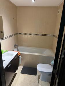 a bathroom with a tub and a toilet and a sink at Chez Mamie Kenza in Mohammedia