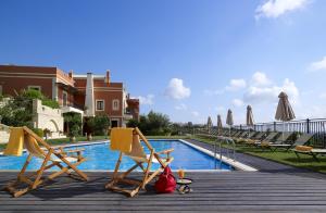 een groep stoelen en parasols naast een zwembad bij Katalagari Country Suites in Archanes