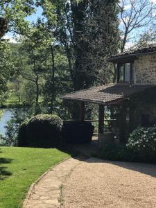 a house with a walkway next to a lake at Le Noyer sur Lot in Prayssac