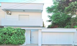 a white house with a white fence at Duplex Marsa Ennessim in Dar el Ouzir +15 photos