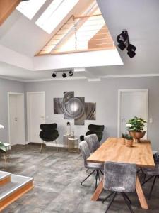 a living room with a wooden table and chairs at SH-Apartment Penthouse 44 - zentral & einzigartig in Erfurt