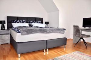 a bedroom with a large bed and a chair at SH-Apartment Penthouse 44 - zentral & einzigartig in Erfurt