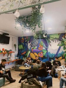 a group of people sitting in a room with a mural at WOT Patio Social in Lisbon