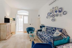 un soggiorno con divano e piatti appesi al muro di Albachiara Home ad Andria