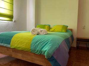 zwei Handtücher auf einem Bett mit bunten Laken in der Unterkunft Torete in Roquetas de Mar