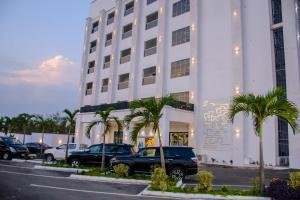 ein weißes Gebäude mit davor geparkten Autos in der Unterkunft G-Pinnacle Signature in Ilorin