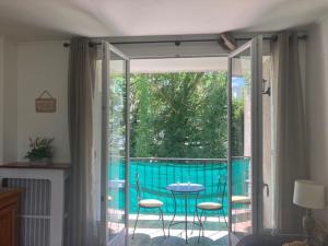 a room with a patio with a table and chairs at Appartement au calme pour 4 - résidence arborée - Proche Paris 20 min in Draveil