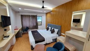 a hotel room with a bed and a desk at Hotel Dhruv Palace in Trimbak