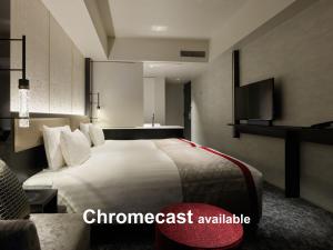 a hotel room with a bed and a tv at Mitsui Garden Hotel Fukuoka Nakasu in Fukuoka