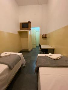 a hospital room with two beds and a table at Hotel Central in Araçatuba