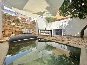a room with a pool of water and a stone wall at Lu Parmientu in Parabita
