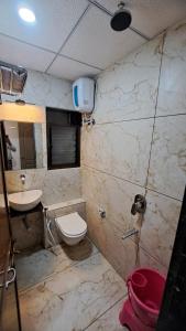 a bathroom with a toilet and a sink at Hotel Dhruv Palace in Trimbak