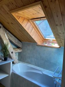 a bathroom with a large bath tub in a attic at Superbe duplex cosy au cœur de Mônetier Les Bains in Le Monêtier-les-Bains