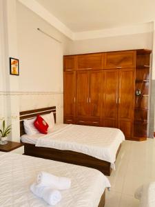 a bedroom with two beds and a wooden cabinet at Anna homestay- Đông Tác, Tuy Hoà, Phú Yên in Ðông Tác (1)