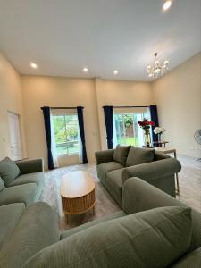 a living room with two couches and a table at Villa Lacroix Organic Farm in San Pa Tong