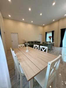 a dining room with a wooden table and a couch at Villa Lacroix Organic Farm in San Pa Tong