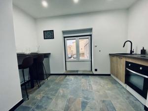 a kitchen with a counter and a sink and a window at nuit d exception avec jacuzzi in Bourg-de-Péage