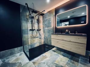 a bathroom with a shower and a sink and a mirror at nuit d exception avec jacuzzi in Bourg-de-Péage +3 photos