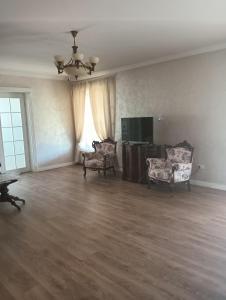 un salon vide avec deux chaises et une télévision à écran plat dans l'établissement Clarice, 