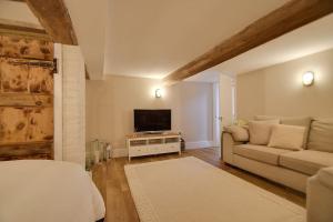 a living room with a couch and a television at Blossom Lodge in Worcester