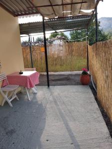 a patio with a table and chairs and a fence at LittleParadise100MFromTheBeach in Áyioi Apóstoloi